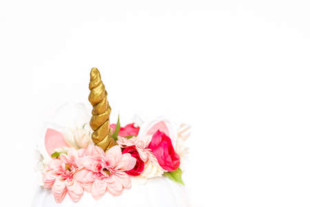 Craft pumpkin painted white and decorated with pink flowers as unicorn on white background.の写真素材