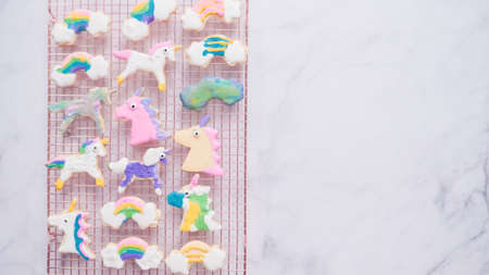 Unicorn cookies decorated with royal icing drying on drying rack.の写真素材