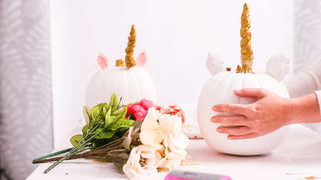Woman decorating craft pumpkin with unicorn theme for Halloween.の写真素材