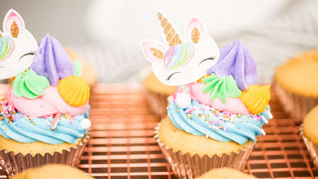 Step by step. Decorating unicorn themed vanilla cupcakes with rainbow buttercream frosting.の写真素材