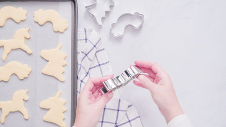 Unicorn shaped sugar cookies on baking sheet.