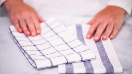 Folding blue and white patterned paper towels on marble surface.の写真素材