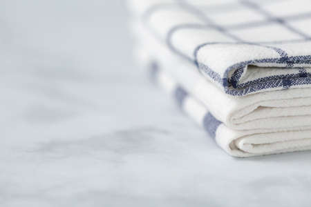 New kitchen towels with simple blue pattern folded on marble counter.の写真素材