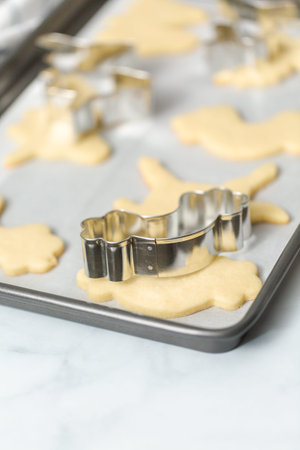Unfinished unicorn shape sugar cookies on the baking sheet.