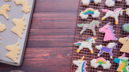Unicorn cookies decorated with royal icing drying on drying rack.の写真素材