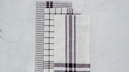 Folding Blck and white patterned paper towels on marble surface.