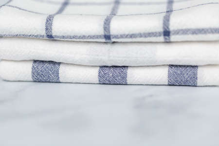 New kitchen towels with simple blue pattern folded on marble counter.の写真素材