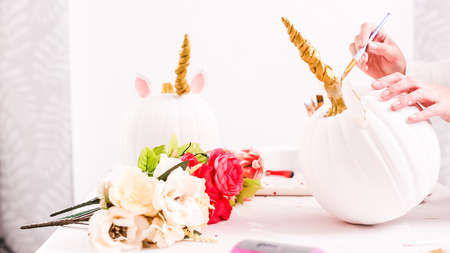 Woman decorating craft pumpkin with unicorn theme for Halloween.の写真素材