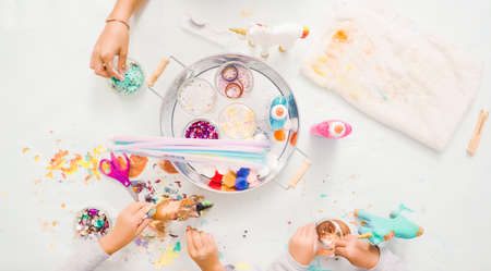 Step by step. Little girls painting paper mache unicorn with acrylic paint.の写真素材