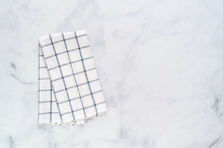 New kitchen towels with simple blue pattern folded on marble counter.の写真素材
