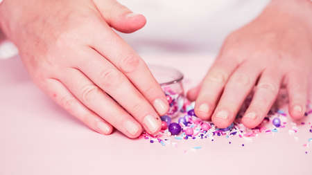 Colorful purple sprinkle blend on a pink background.の写真素材
