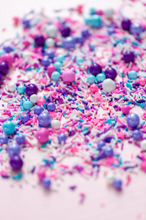Colorful purple sprinkle blend on a pink background.の写真素材