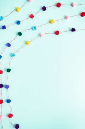 Pom pom colorful party garland on blue backgrouns.の写真素材