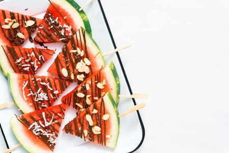 Watermelon drizzled with chocolate and topped with flaked sea salt and almonds.の写真素材