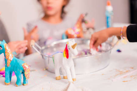 Little girls decorating small paper mache unicorn figurines.の写真素材