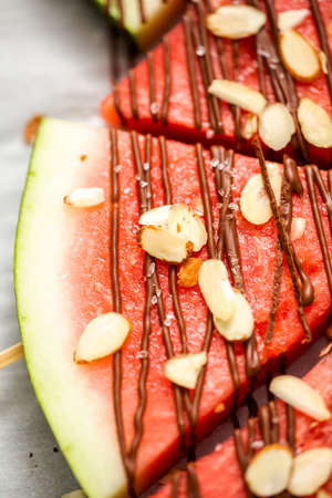 Watermelon drizzled with chocolate and topped with flaked sea salt and almonds.の写真素材
