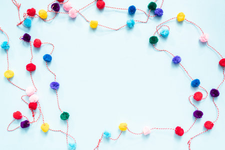 Pom pom colorful party garland on blue backgrouns.