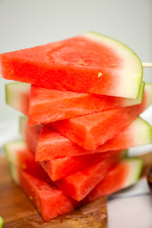 Sliced watermelon in triangle shapes on wooden sticks.の写真素材