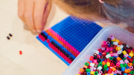 Little girl making bracelet from colorful kids beads.の写真素材