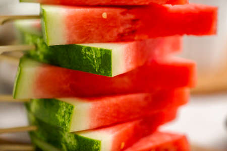 Sliced watermelon in triangle shapes on wooden sticks.の写真素材