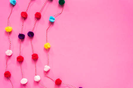 Pom pom colorful party garland on pink backgrouns.の写真素材