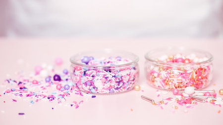 Colorful sprinkle blend on a pink background.