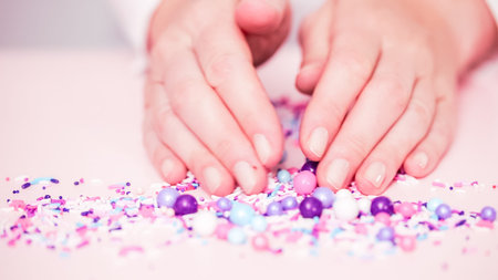 Colorful purple sprinkle blend on a pink background.の写真素材