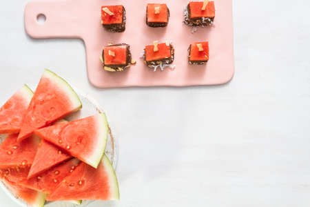 Preparing watermelon appetizers dipped in chocolate and sprinked with sea salt and almonds.の写真素材