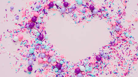 Colorful purple sprinkle blend on a pink background.の写真素材