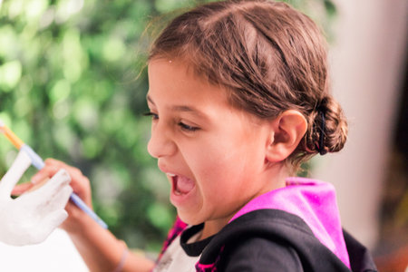Little girls decorating small paper mache unicorn figurines.
