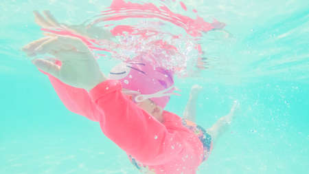 Little girl having fun swimming in outdoor pool in the Summer.の写真素材