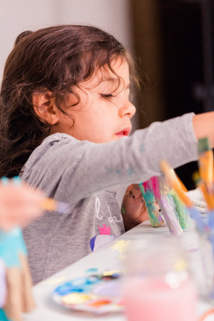 Little girls decorating small paper mache unicorn figurines.の写真素材