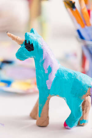 Girls decorating their small paper mache unicorns figurines at the unicorn extravaganza party.の写真素材