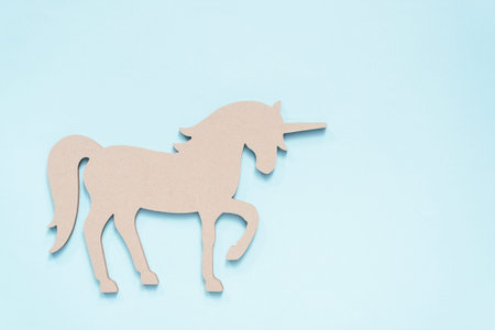 Unfinished unicorn cut out on blue background.