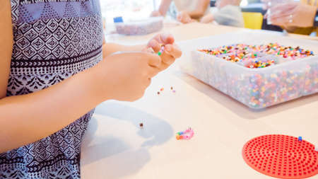 Little girl making bracelet from colorful kids beads.の写真素材