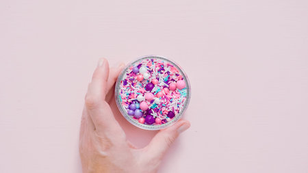 Colorful purple sprinkle blend on a pink background.