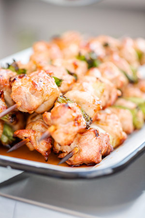 Step by step. Chicken yakitori with scallions on white metal serving tray.の写真素材