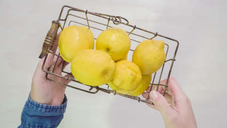 Step by step. Slicing fresh organic lemons on a white wood cutting board.の写真素材