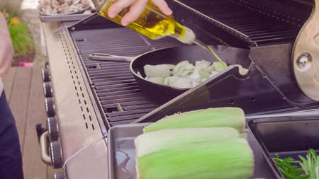 Step by step. Grilled mushrooms and onions in cast iron frying pan on outdoor gas grill.の写真素材