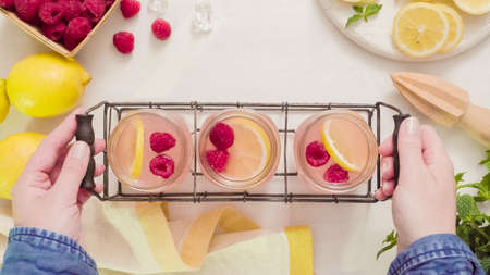 Raspberry lemonade in drinking mason jars on a wood table.の写真素材