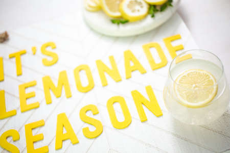 it's lemonade season wood sign with glass of fresh lemonade.の写真素材