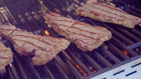 Step by step. Grilling New York strip steak on outdoor gas grill.の写真素材