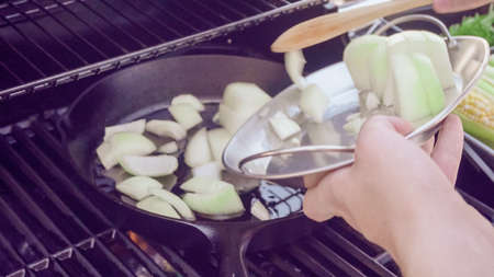 Step by step. Grilled mushrooms and onions in cast iron frying pan on outdoor gas grill.の写真素材