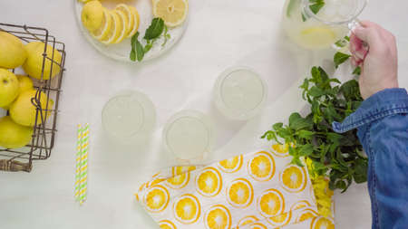 Step by step. Pouring traditional fresh lemonade in glasses.の写真素材