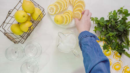 Step by step. Preparing traditional fresh lemonade in glass pitcher.の写真素材