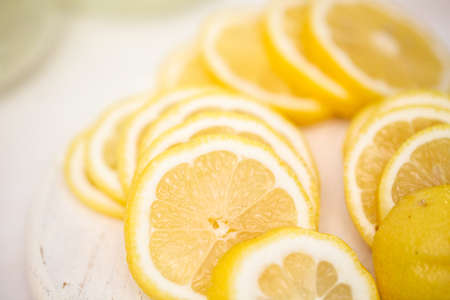 Fresh sliced lemon on a white wood cutting board.の写真素材