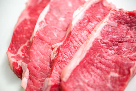 Raw New York strip steaks on a white background.の写真素材