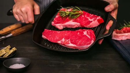 Raw New York strip steaks in cast iron frying pan.の写真素材