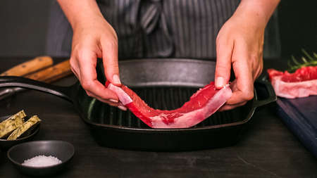 Raw New York strip steaks in cast iron frying pan.の写真素材