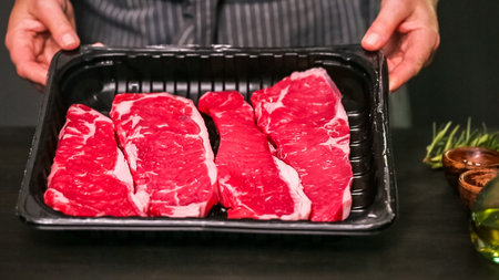 Raw New York strip steaks on a wood cutting board.の写真素材